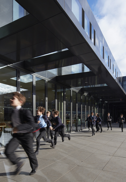 AKG7229696.webp Enfants courant devant un bâtiment moderne – Image 1