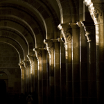 Arcades en pierre d'un cloître médiéval avec jeu de lumière