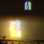 Lumière colorée d'un vitrail projetée sur un mur