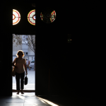 Une femme entrant par une porte éclairée de lumière naturelle