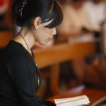 Femme lisant un livre dans un lieu de prière