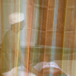 Personnes méditant derrière un rideau coloré