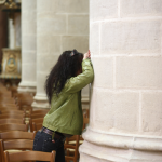 Femme contre un pilier dans une église.