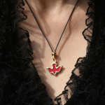 Collier avec pendentif rouge et doré sur fond de dentelle noire