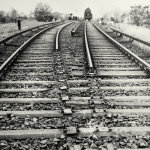 Rails ferroviaires convergents avec train à l'horizon