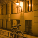 Vélo enneigé sous lampadaire dans une rue nocturne