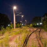 Voie ferrée éclairée la nuit avec feux de signalisation