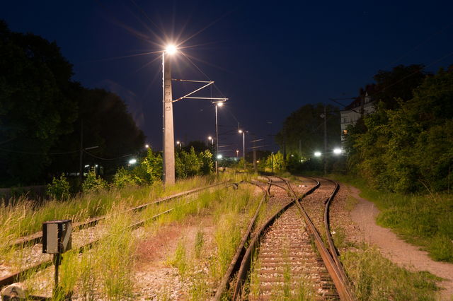 AKG7298086.webp Voie ferrée éclairée la nuit avec feux de signalisation – Image 1