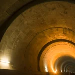 Tunnel illuminé avec lumières jaunes et murs texturés