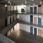 Balcon d'un immeuble moderne avec deux personnes discutant