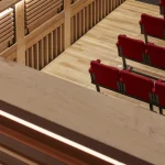 Sièges rouges et structure en bois d'une salle de spectacle contemporaine