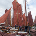 Bateaux avec voiles rouges au port avec équipage