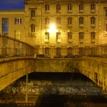 Pont illuminé et bâtiment ancien la nuit