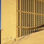 Personne montant des escaliers devant un bâtiment moderne au coucher du soleil