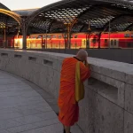 Moine Photographiant un Train dans une Gare