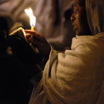 Femme priant à la lumière d'une bougie