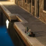 Lecture près d'un canal en soirée