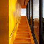 Escalier intérieur jaune avec fenêtres panoramiques