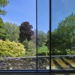 Vue d'un jardin par une grande baie vitrée