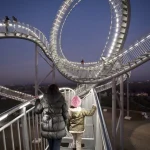 Structure de randonnée en boucle illuminée avec piétons en soirée