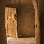 Vieille porte en bois dans un couloir en pierre
