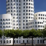 Bâtiment moderne avec personne bronzant sous des arbres