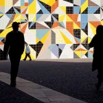 Silhouettes devant une fresque géométrique colorée