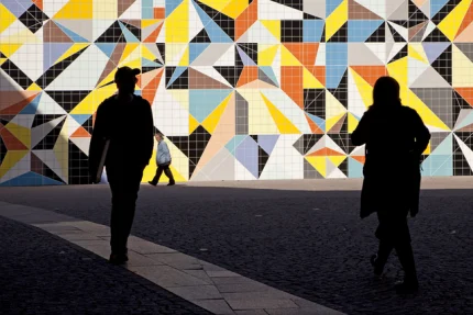 Silhouettes devant une fresque géométrique colorée