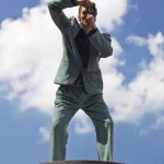 Photographe en haut d'une colonne prenant une photo sous le ciel bleu