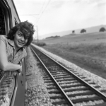 Personne souriante regardant par la fenêtre d'un train en marche