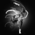 Danseuse en mouvement capturée par un effet de pose longue en noir et blanc.