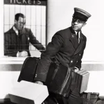 Portier transportant des bagages devant un guichet de tickets