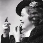 Femme appliquant du rouge à lèvres avec un miroir à main