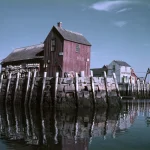Maisons en bois sur quai au bord de l'eau reflétées