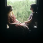 Deux femmes assises dans un cadre de fenêtre éclairé