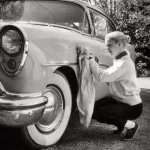 Femme nettoyant une voiture classique en extérieur