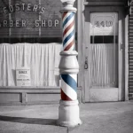 Ancienne enseigne de barbier devant une boutique