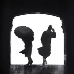 Deux personnes avec des parapluies dans un passage sombre