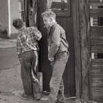 Deux garçons fumant près d'une palissade en bois