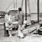 Couple discutant sur un quai devant des bateaux