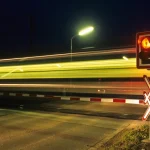 Train traversant une voie ferrée la nuit