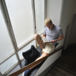 Homme lisant près d'une fenêtre dans un escalier
