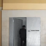 Homme entrant dans un bâtiment moderne