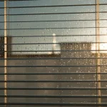 Store en vénitien avec gouttes de pluie contre la lumière du jour