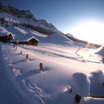 Chalets enneigés au lever du soleil dans les montagnes