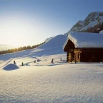 Chalet en bois sous la neige au lever du soleil