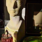 Buste en plâtre éclairé avec divers objets colorés