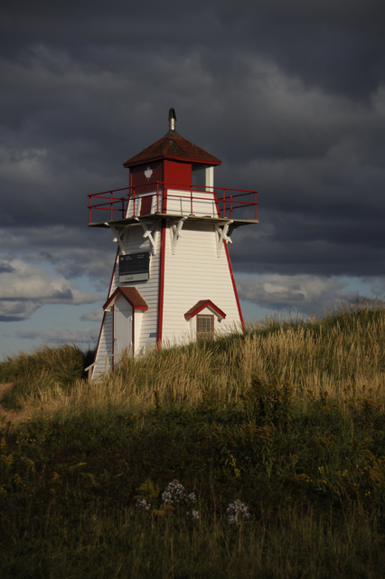 AKG7877691.webp Phare rouge et blanc sous un ciel nuageux – Image 1