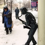 Statue de musicien et homme dans une rue enneigée
