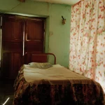 Chambre rustique avec lit simple et rideaux fleuris